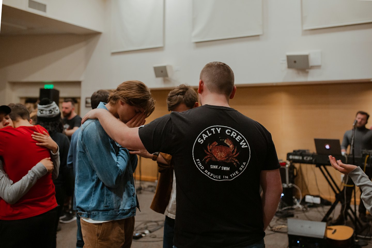 Friends gather to comfort each other in a music studio.